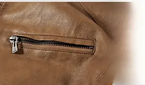 Close-up of a brown PU leather jacket featuring a silver metal zipper pocket and texture
