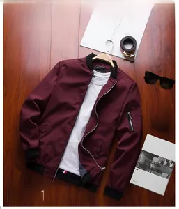 Macro shot of burgundy bomber jacket details with ribbed cuffs and sleeve zipper pocket