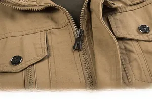 Detail of khaki cotton utility jacket featuring heavy metal zipper and flap pocket design