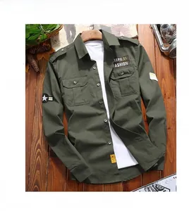 Detail of olive green cotton utility shirt featuring shoulder epaulettes and military patches