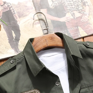 Detail of army green cargo shirt featuring shoulder epaulettes and embroidered badge