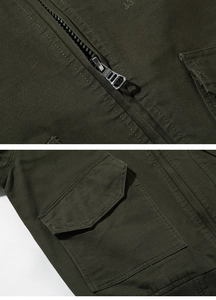 Detail of army green utility jacket showing durable cotton fabric and sport metal zipper