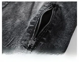 Détail de la veste en jean gris anthracite montrant la poche zippée et la texture délavée