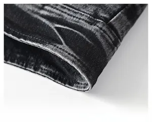 Gros plan sur l'ourlet d'une veste en jean gris foncé délavé avec coutures précises