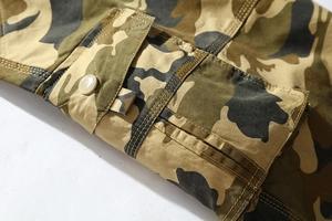 Close-up of camouflage cotton cargo shorts featuring a buttoned flap pocket and durable stitching