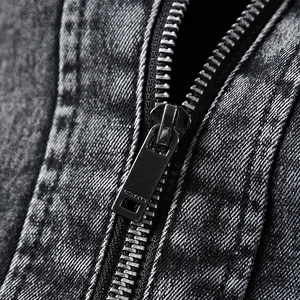 Détail macro d'une fermeture éclair en métal sur une veste en denim gris foncé lavé