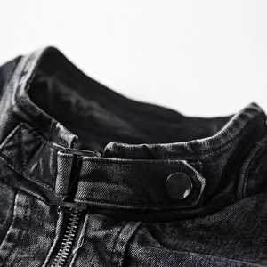 Détail du col d'une veste en jean noir délavé vintage avec boutons pressions et zip