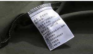 Detailed view of the 100% cotton wash label on a men's military style long sleeve shirt