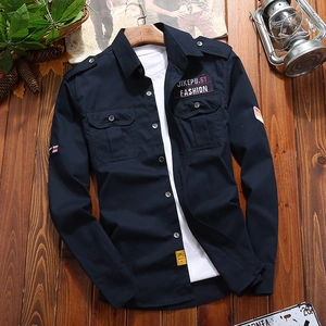Men's navy cotton long sleeve work shirt with cargo pockets and patches on wood floor