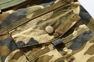 Close-up of camouflage cargo shorts showing side pocket with durable stitching and metal button