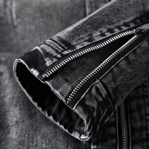 Détail du poignet d'une veste en denim gris foncé avec fermeture éclair métallique robuste