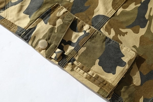 Detail of cargo short side pocket with metallic snap button and camouflage twill cotton fabric