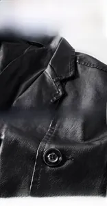 Close-up of black PU leather texture with glossy round buttons on a men's slim-fit blazer