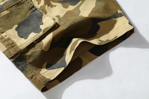 Detailed close-up of jungle camouflage cargo shorts featuring durable cotton stitching
