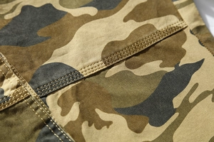 Macro detail of men's camo cargo shorts showing durable double-stitched cotton fabric