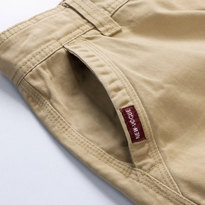 Detalle macro del tejido de sarga de algodón caqui y etiqueta tejida New-Vogue en el pantalón