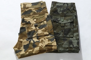 Detail of cargo shorts in tan and olive camouflage featuring large flap side pockets