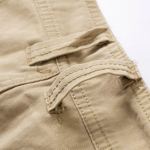 Detalle macro de los pantalones cortos cargo caqui con tejido de sarga y trabillas de cinturón