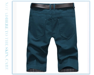 Detail of dark teal cotton shorts featuring two back pockets and a stylish leather belt