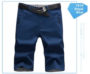 Detail view of royal blue shorts with plaid lining and black leather belt accessory