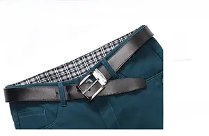 Detail of teal casual shorts waistband with black textured leather belt and silver buckle