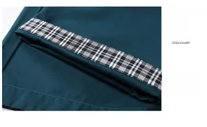 Detailed close-up of dark green shorts showing plaid cuff lining and neat stitching