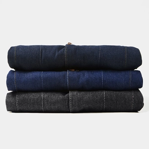 Trois vestes en jean empilées en bleu foncé, bleu moyen et gris avec détails de texture