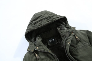 Dettaglio del parka verde militare con la spessa fodera in pile di lana di agnello grigio