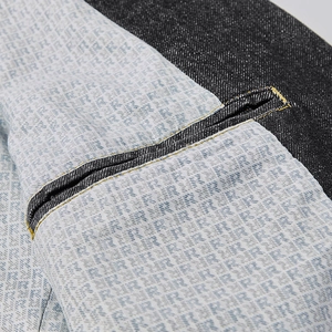 Détail d'une veste en jean foncée avec doublure imprimée et coutures contrastées