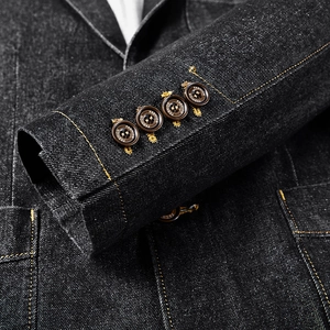 Détail de la manche d'un blazer en jean avec boutons marron et coutures contrastées