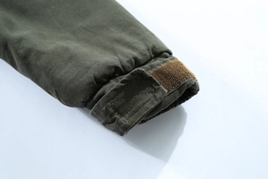 Dettaglio del polsino regolabile con velcro su giacca invernale verde oliva