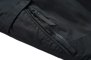 Vista dettagliata della tasca con cerniera di un parka nero con tessuto in saia resistente