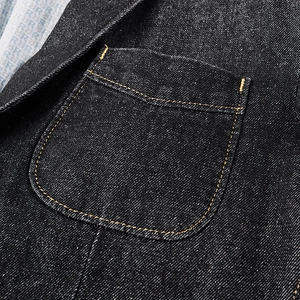 Détail d'une veste en jean foncée avec coutures jaunes contrastées et doublure rayée