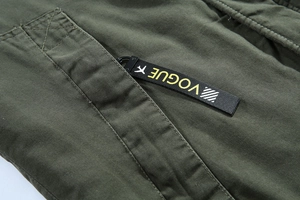 Dettaglio della giacca verde militare con tessuto in cotone e nastro intrecciato Vogue