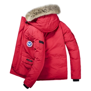 Dettaglio del parka rosso con cappuccio in pelliccia e toppa ricamata sulla manica