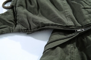 Dettaglio ravvicinato del parka invernale verde militare con cerniera e fodera in pelliccia