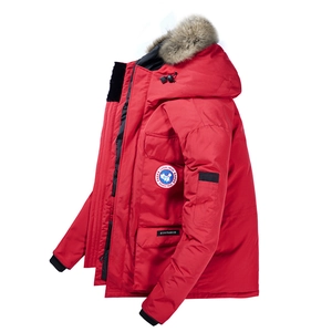 Dettaglio di un parka invernale rosso con cappuccio in pelliccia e toppa sul petto