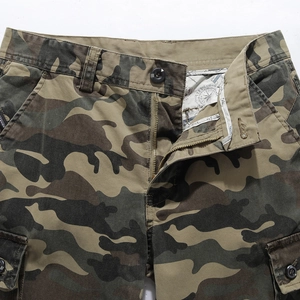 Detailed close-up of forest camouflage cargo pants waist with metal zipper and hardware