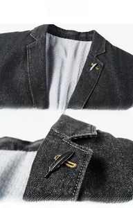 Détail du col de blazer en jean noir avec coutures orange et une broche plume argentée