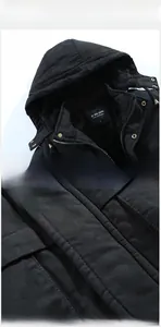 Dettaglio del parka nero con cappuccio che mostra colletto, fodera interna e cuciture