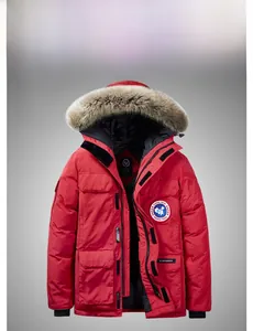 Dettaglio di parka rosso con collo in pelliccia spessa e stemma circolare della marca sul petto
