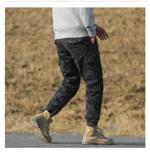 Detail view of camouflage cargo pants featuring side flap pockets and drawstring cuffs
