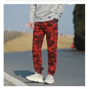 Detailed close-up of red camo cargo pants featuring large side flap pockets and cuffed hem