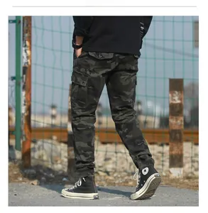 Outdoor street style detail of camouflage cargo pants with side pockets and cuffed ankles
