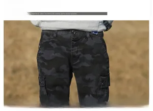 Detail view of dark camo cargo pants featuring a sturdy waistband and large flap pockets