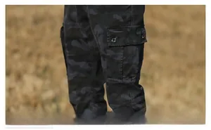 Detail of cargo pocket with button flap on camouflage tactical pants in dark grey