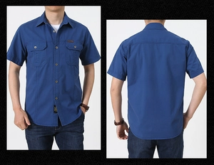 Détail d'une chemise de travail en coton bleu marine avec poches poitrine et ourlet arrondi