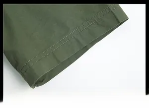 Détail du poignet d'une chemise vert armée avec double couture durable et texture fine