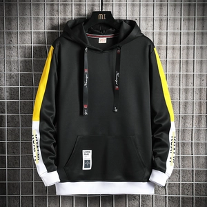 Détail du sweat à capuche noir avec bandes contrastées jaunes et blanches aux manches