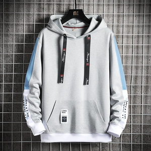 Détail du sweat à capuche gris avec manches bleu clair, rayures et poche kangourou